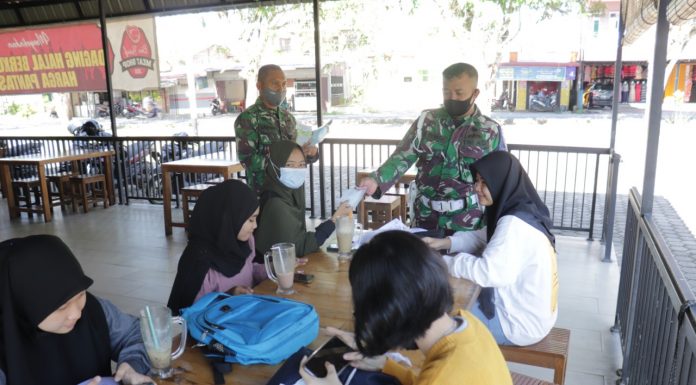 Bagikan Masker Kepada Pangunjung Cafe, Anggota Zidam XII/Tpr Ingatkan Pentingnya Prokes