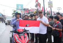 Dibawah Guyuran Hujan, Pj Bupati Landak Tetap Semangat Kibarkan dan Bagian Bendera Merah Putih