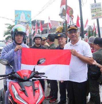 Dibawah Guyuran Hujan, Pj Bupati Landak Tetap Semangat Kibarkan dan Bagian Bendera Merah Putih
