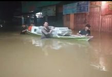 Lewati Banjir, Anggota Polsek Menyuke Bantu Kawal Logistik Pilkada Gunakan Perahu