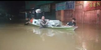Lewati Banjir, Anggota Polsek Menyuke Bantu Kawal Logistik Pilkada Gunakan Perahu