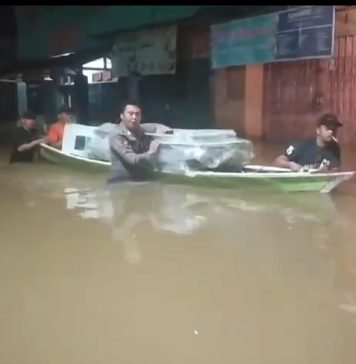 Lewati Banjir, Anggota Polsek Menyuke Bantu Kawal Logistik Pilkada Gunakan Perahu