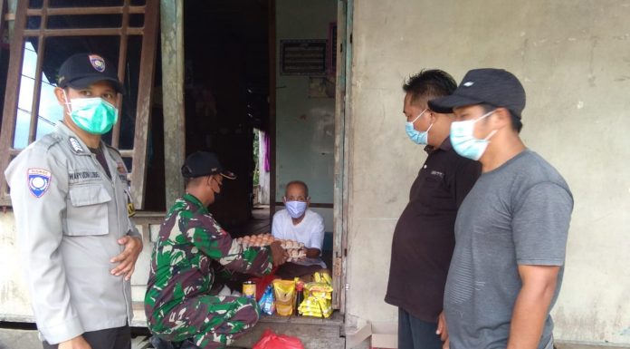 Babinsa Bersama Bhabinkamtinas dan Perangkat Desa Air Besar Bagikan Sembako Kepada Warga