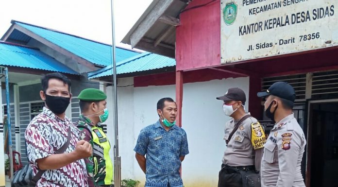 Babinsa Koramil Sengah Temila Bersama Bhabinkamtibmas dan Kepala Desa Sidas Jalin Komunikasi Bahasa Efek Pandemi Covid-19
