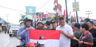 Dibawah Guyuran Hujan, Pj Bupati Landak Tetap Semangat Kibarkan dan Bagian Bendera Merah Putih