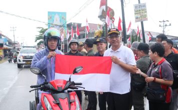 Dibawah Guyuran Hujan, Pj Bupati Landak Tetap Semangat Kibarkan dan Bagian Bendera Merah Putih