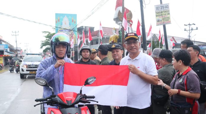 Dibawah Guyuran Hujan, Pj Bupati Landak Tetap Semangat Kibarkan dan Bagian Bendera Merah Putih