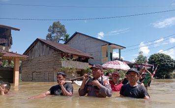 Gunakan Tandu, Polisi Bantu Evakuasi Warga Sakit Terobos Banjir