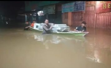 Lewati Banjir, Anggota Polsek Menyuke Bantu Kawal Logistik Pilkada Gunakan Perahu