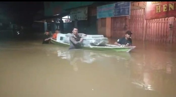 Lewati Banjir, Anggota Polsek Menyuke Bantu Kawal Logistik Pilkada Gunakan Perahu