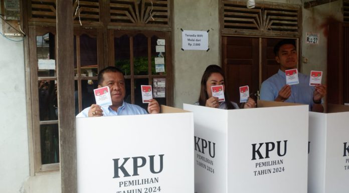 Heri Saman Salurkan Hak Suara di TPS 06 Didampingi Anak-Istri